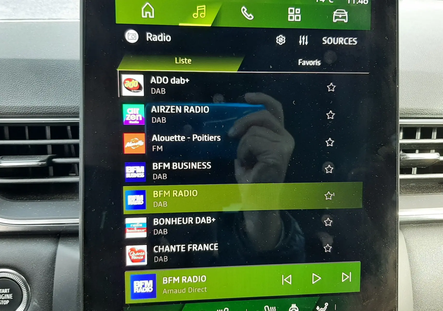 Écran tactile central du tableau de bord Renault Symbioz blanc nacré 2025, affichant la liste des radios DAB avec commandes climatisation en dessous.