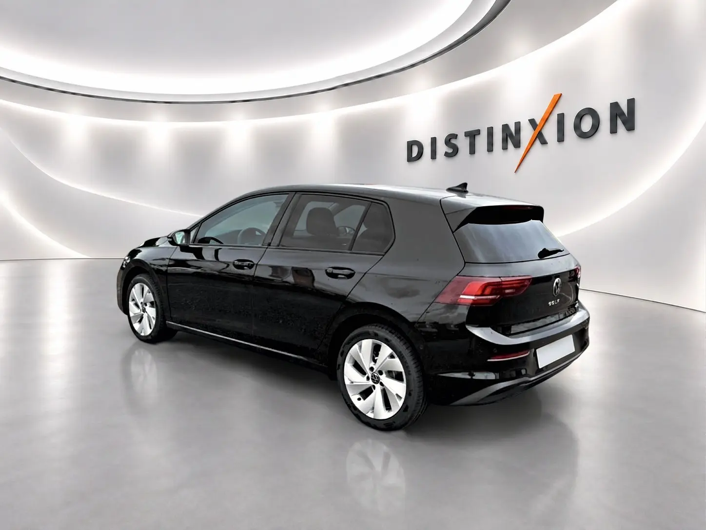 Volkswagen Golf noir vue 3/4 arrière droit dans un showroom lumineux avec jantes alu 17 pouces.