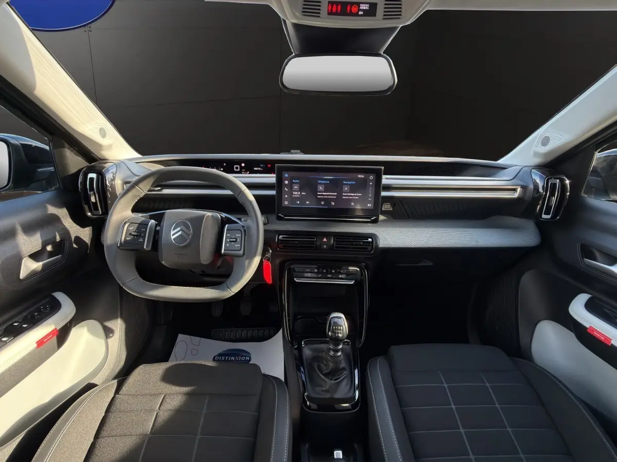 Vue intérieure avant de la Citroën C3 Turbo 100 BVM6 MAX 2025, volant cuir, écran tactile 10,25 pouces, sièges noirs.