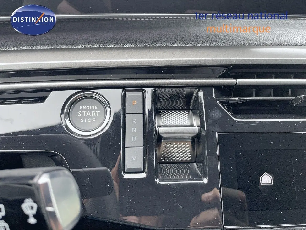 Gros plan sur la console centrale du Peugeot 5008 gris titane avec boutons de boîte auto et bouton start/stop.