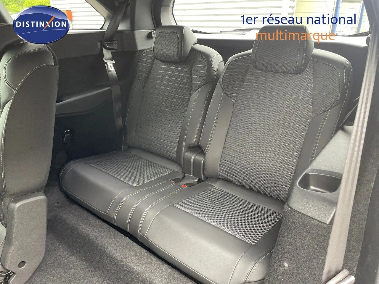 Vue rapprochée des sièges arrière en cuir noir du Peugeot 5008 Hybrid 2025 avec finitions grises et toit noir.