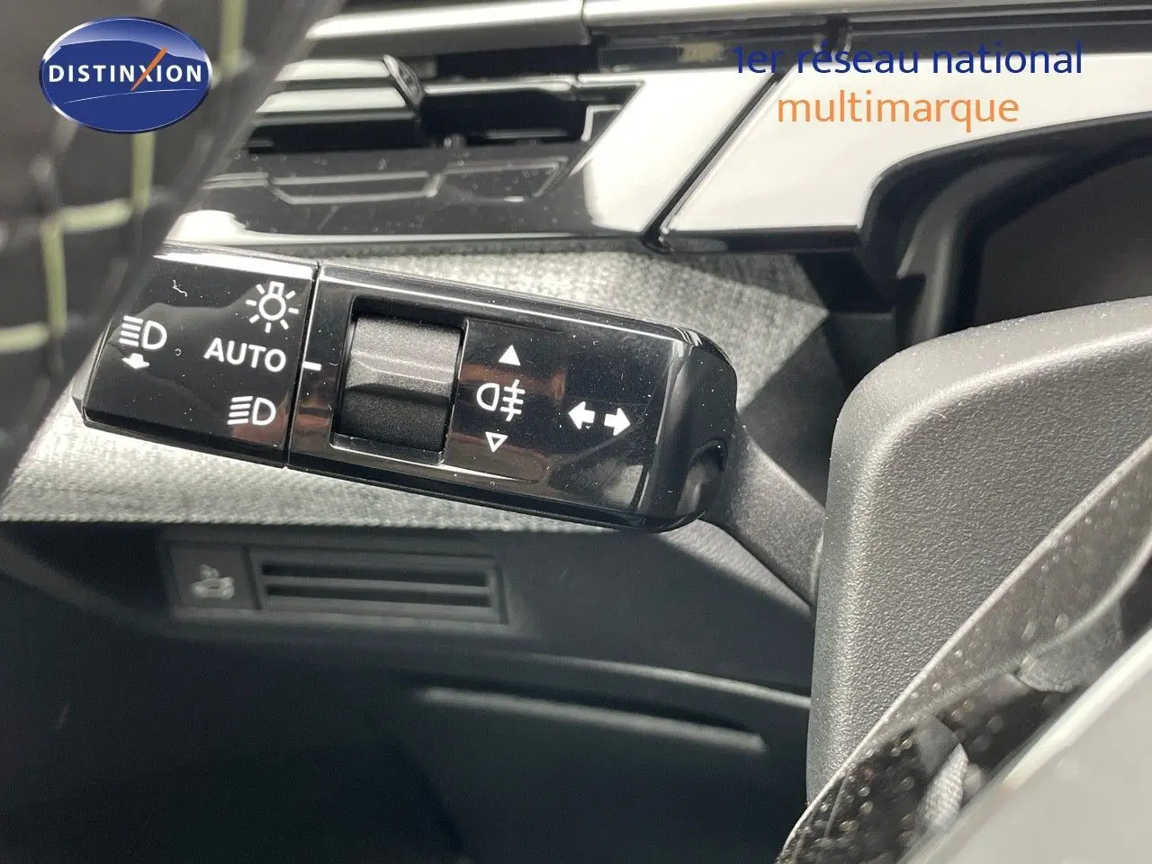 Gros plan sur la commande des feux et clignotants dans l'habitacle du Peugeot 5008 gris titane toit noir.