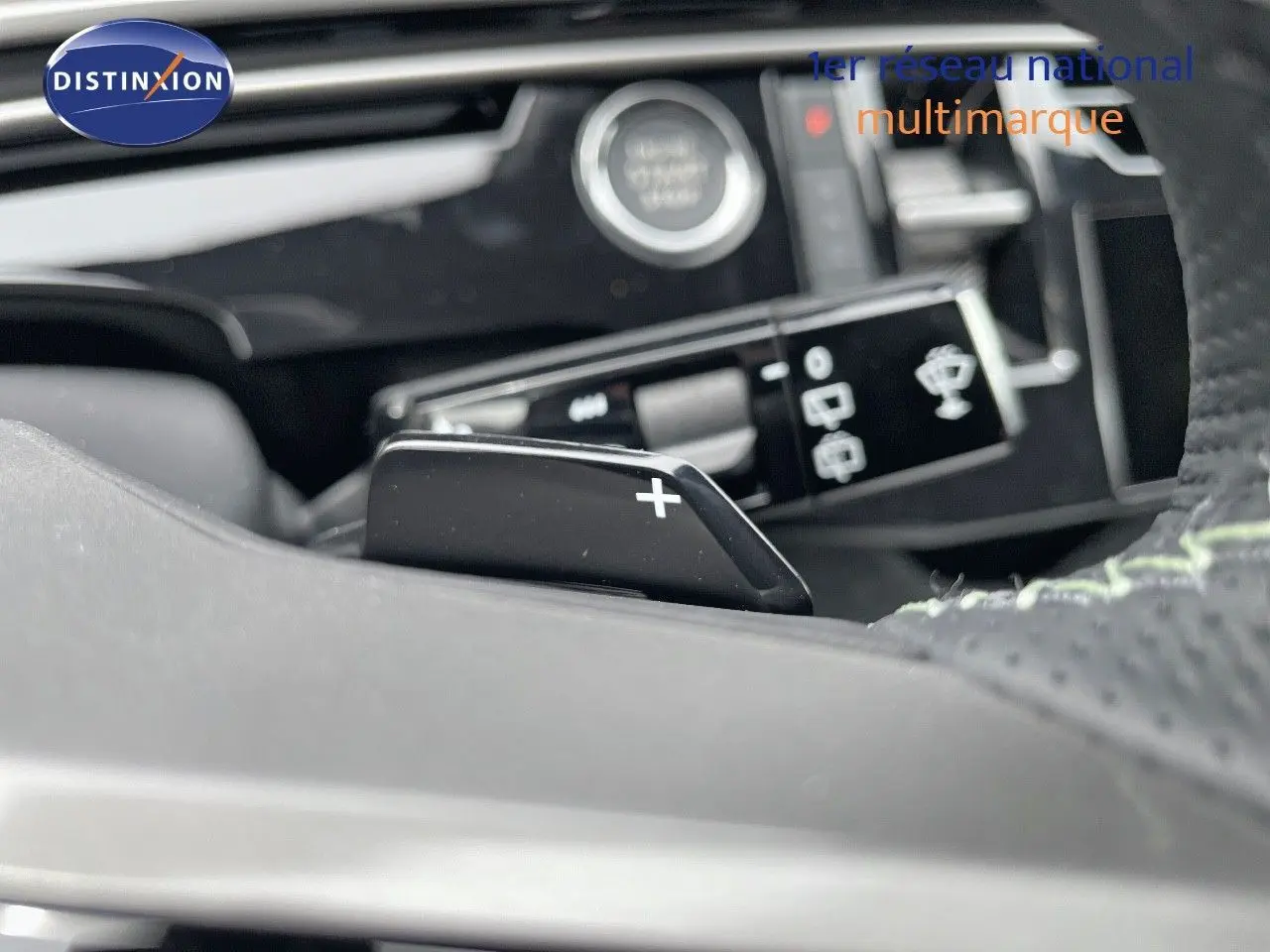 Le levier de commande de boîte automatique avec palettes au volant du Peugeot 5008 Hybrid gris titane toit noir.
