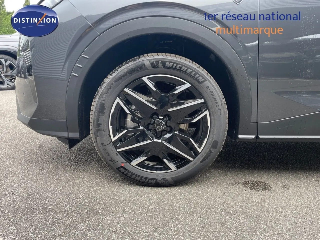 Gros plan sur la roue avant gauche du Peugeot 5008 gris titane avec jante noire et toit noir visible en partie.