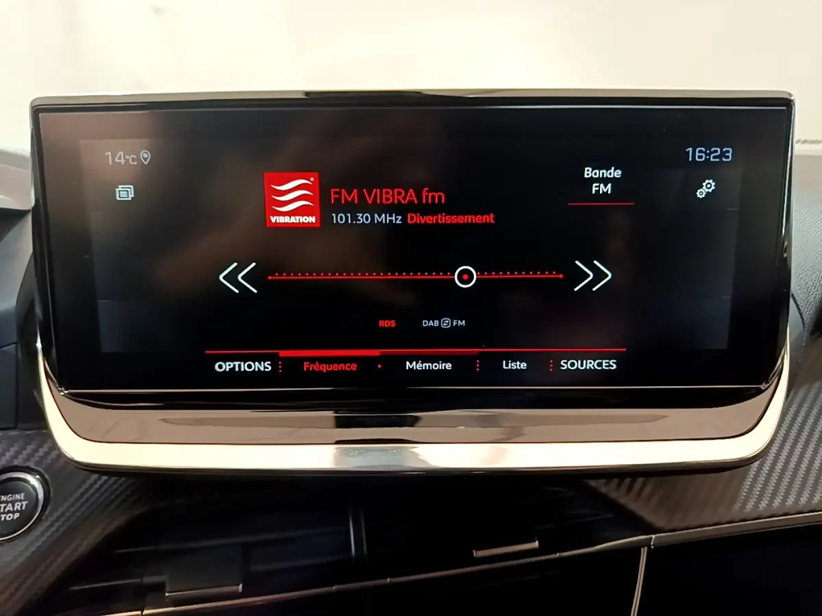 Écran tactile central de 10 pouces affichant la radio FM dans l’habitacle d’une Peugeot 2008 gris clair.