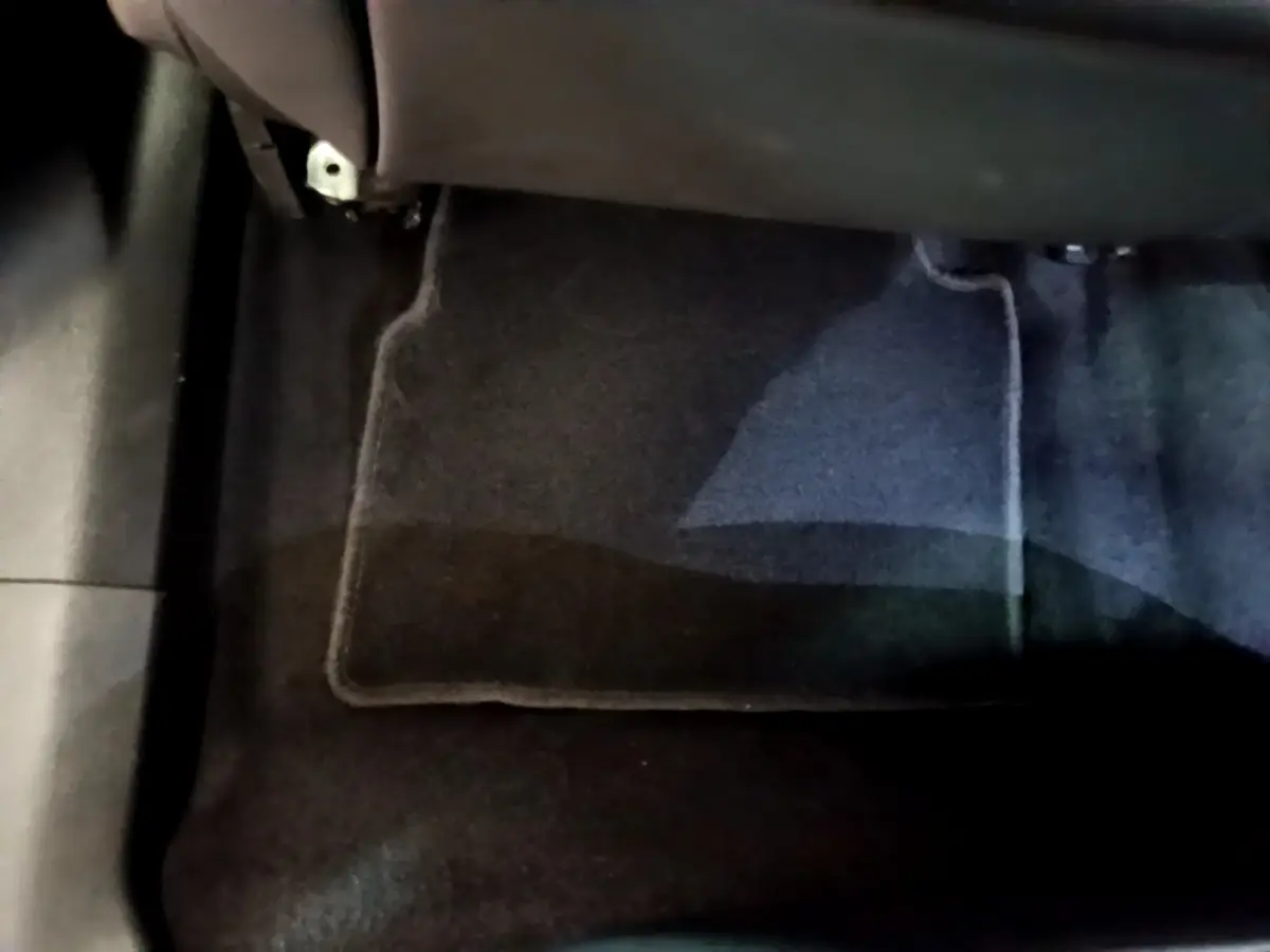 Gros plan sur le tapis de sol noir côté passager avant d’un Peugeot 2008 gris clair de 2021.