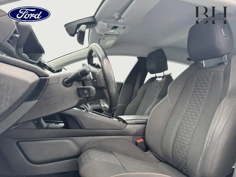 Intérieur avant côté conducteur d'une Peugeot 508 SW gris Platinium, sièges tissu noir avec surpiqûres contrastées.