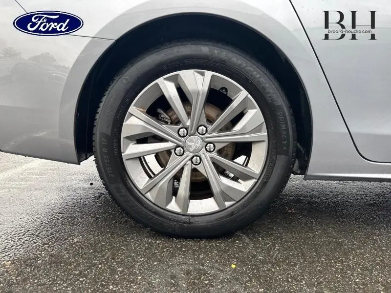 Gros plan sur la roue arrière droite d'une Peugeot 508 SW gris Platinium avec jante alu à dix branches.