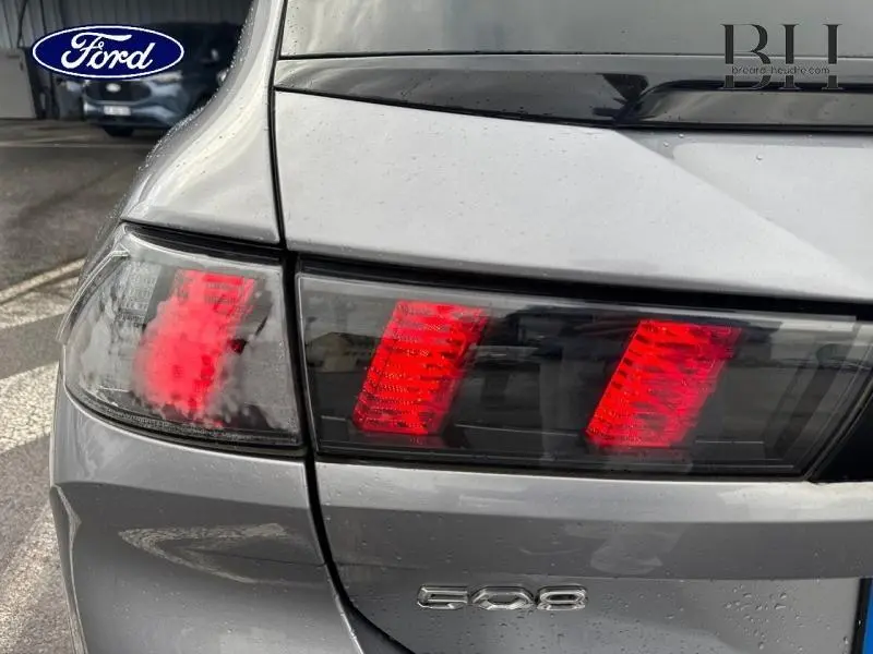 Gros plan sur le feu arrière droit rouge d’une Peugeot 508 SW gris Platinium avec logo 508 visible sur le hayon.