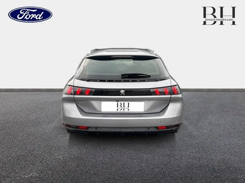 Vue arrière d'une Peugeot 508 SW gris Platinium avec feux arrière LED et hayon fermé sur fond neutre.