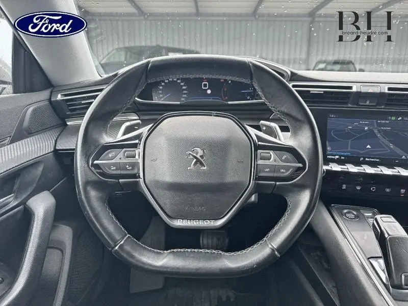 Vue intérieure centrée sur le volant cuir noir du Peugeot 508 SW avec tableau de bord numérique et écran tactile.