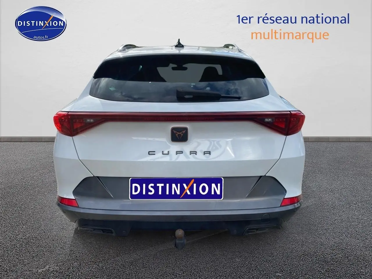 Vue arrière d’un CUPRA Formentor blanc 2023 avec feux LED et attelage visible sur fond neutre.