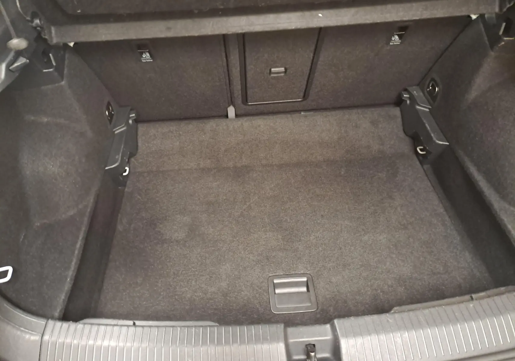 Coffre vide vu de face du Volkswagen T-Roc 2022, finition Life Business, avec intérieur noir et tapis de sol en tissu.