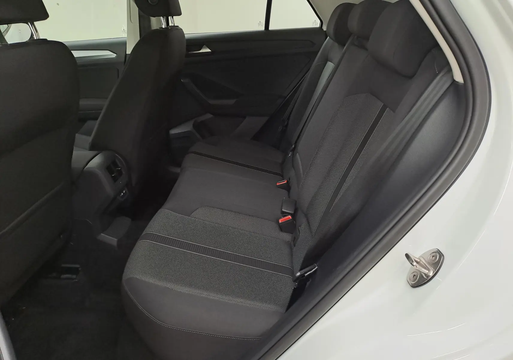 Vue intérieure côté droit sur les sièges arrière noirs du Volkswagen T-Roc blanc pur toit noir, version 2022 essence.