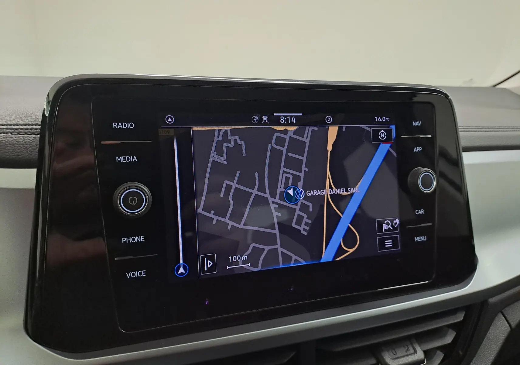 Écran tactile central du Volkswagen T-Roc 2022 affichant la navigation, avec commandes radio et média sur le côté.