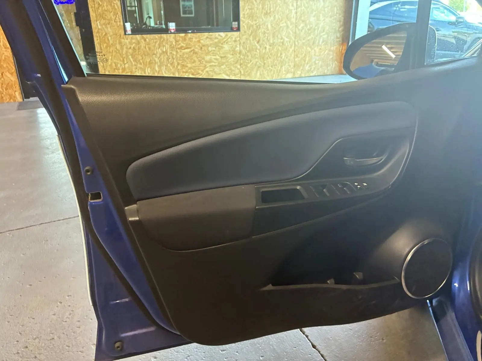 Vue intérieure de la porte avant droite bleu foncé de la Toyota Yaris 1.5 Hybrid Collection 2020 avec haut-parleur rond intégré.