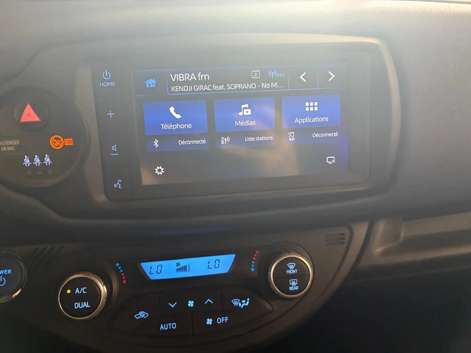 Vue rapprochée de l’écran tactile et de la console de climatisation d’une Toyota Yaris hybride 2020, intérieur noir.