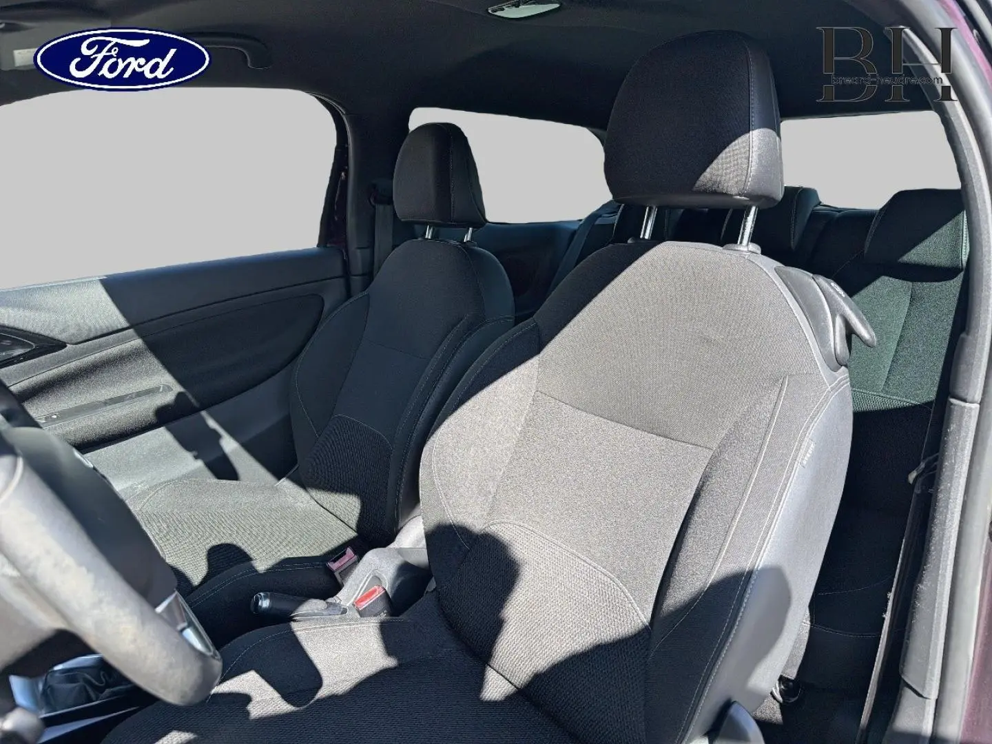 Vue intérieure côté gauche montrant les sièges avant en tissu noir d'une Citroën DS3 rouge Rubi, avec volant partiellement visible.