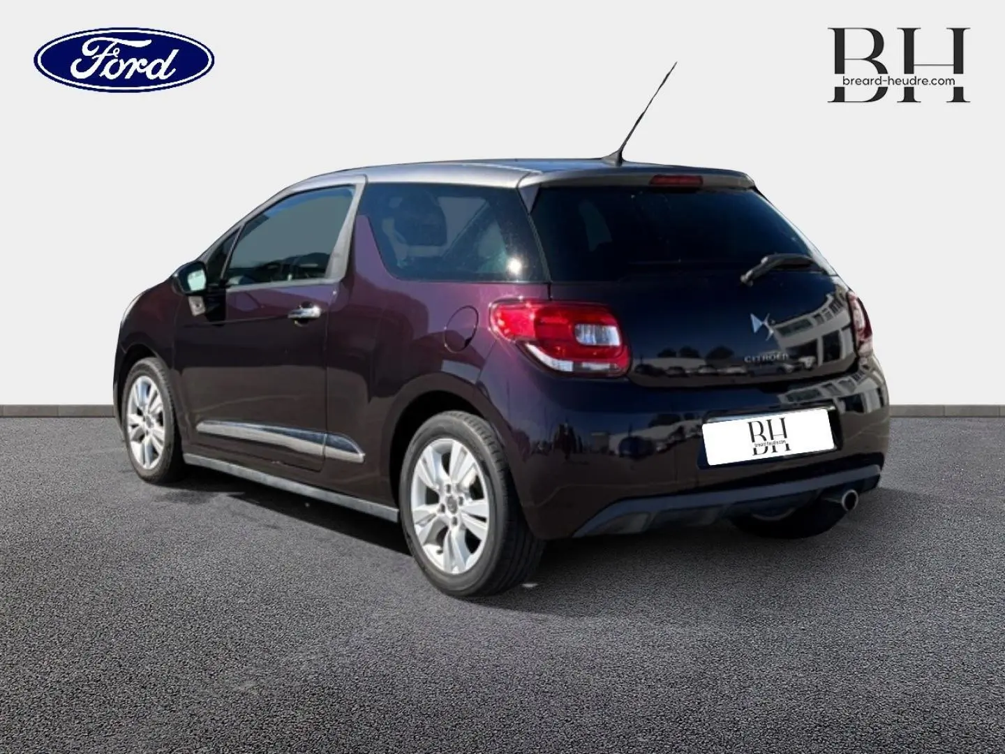 Vue 3/4 arrière droite d'une Citroën DS3 rouge Rubi avec toit noir, jantes alliage et sortie d'échappement chromée.