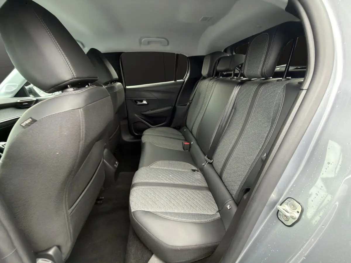 Vue intérieure côté droit sur la banquette arrière en tissu et cuir de la Peugeot 208 gris clair 2025.