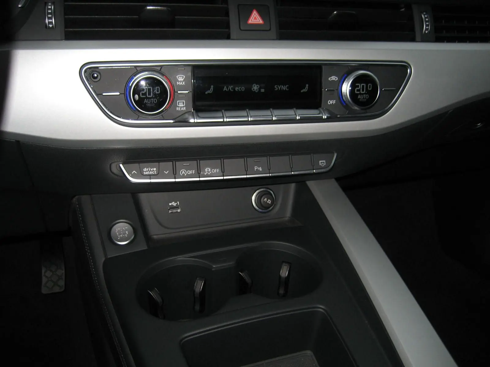 Vue rapprochée de la console centrale de l'Audi A4 Avant noire 2022, mettant en valeur la climatisation digitale et les commandes de conduite.