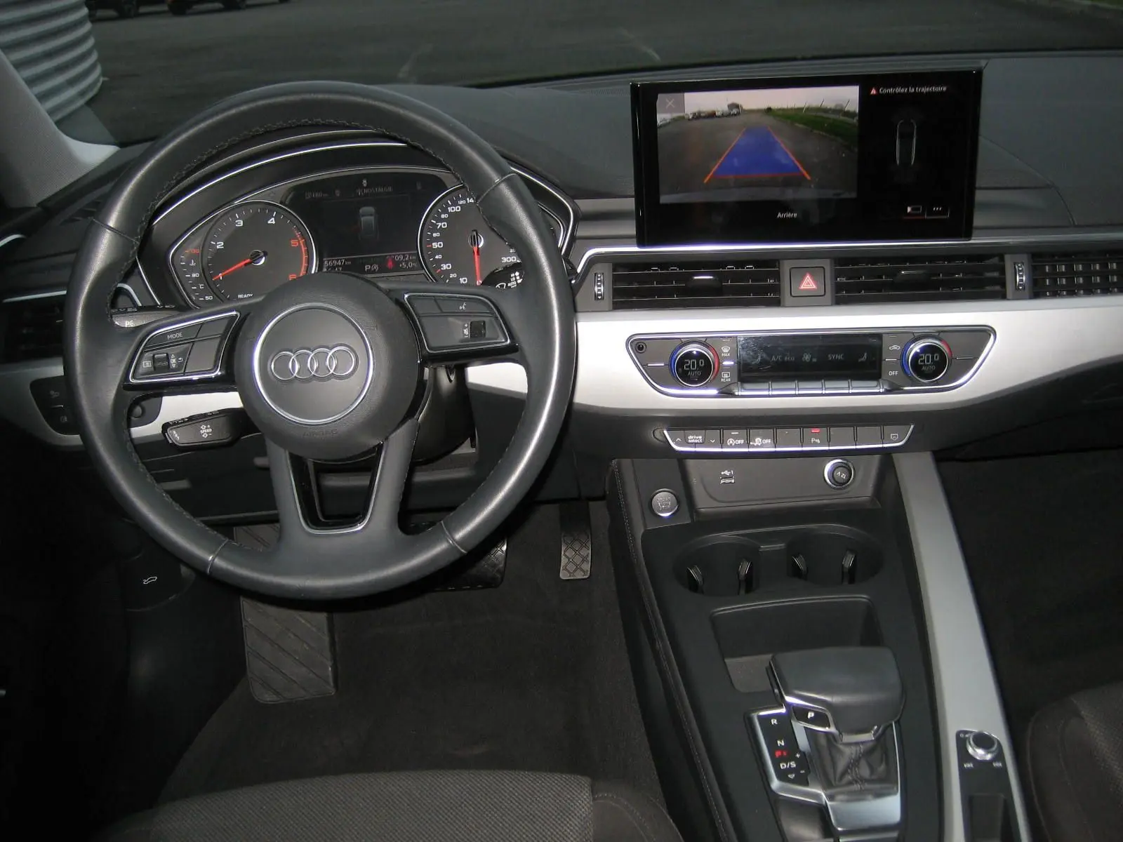Intérieur de l'Audi A4 Avant noir, vue centrée sur le volant et le tableau de bord avec écran de caméra de recul.