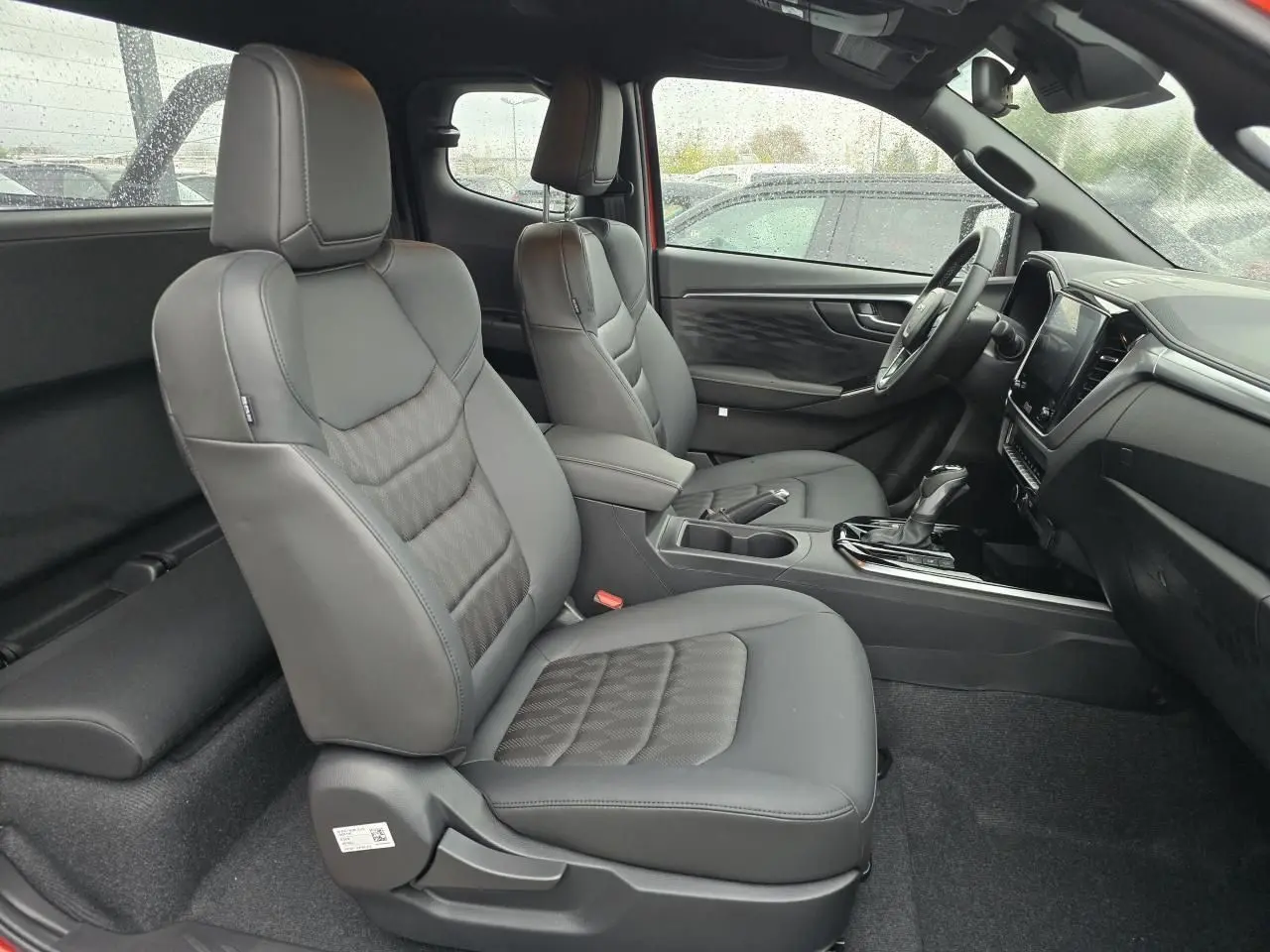 Vue intérieure côté droit du pick-up Isuzu D-MAX 2025 avec sièges en cuir noir et tableau de bord moderne.