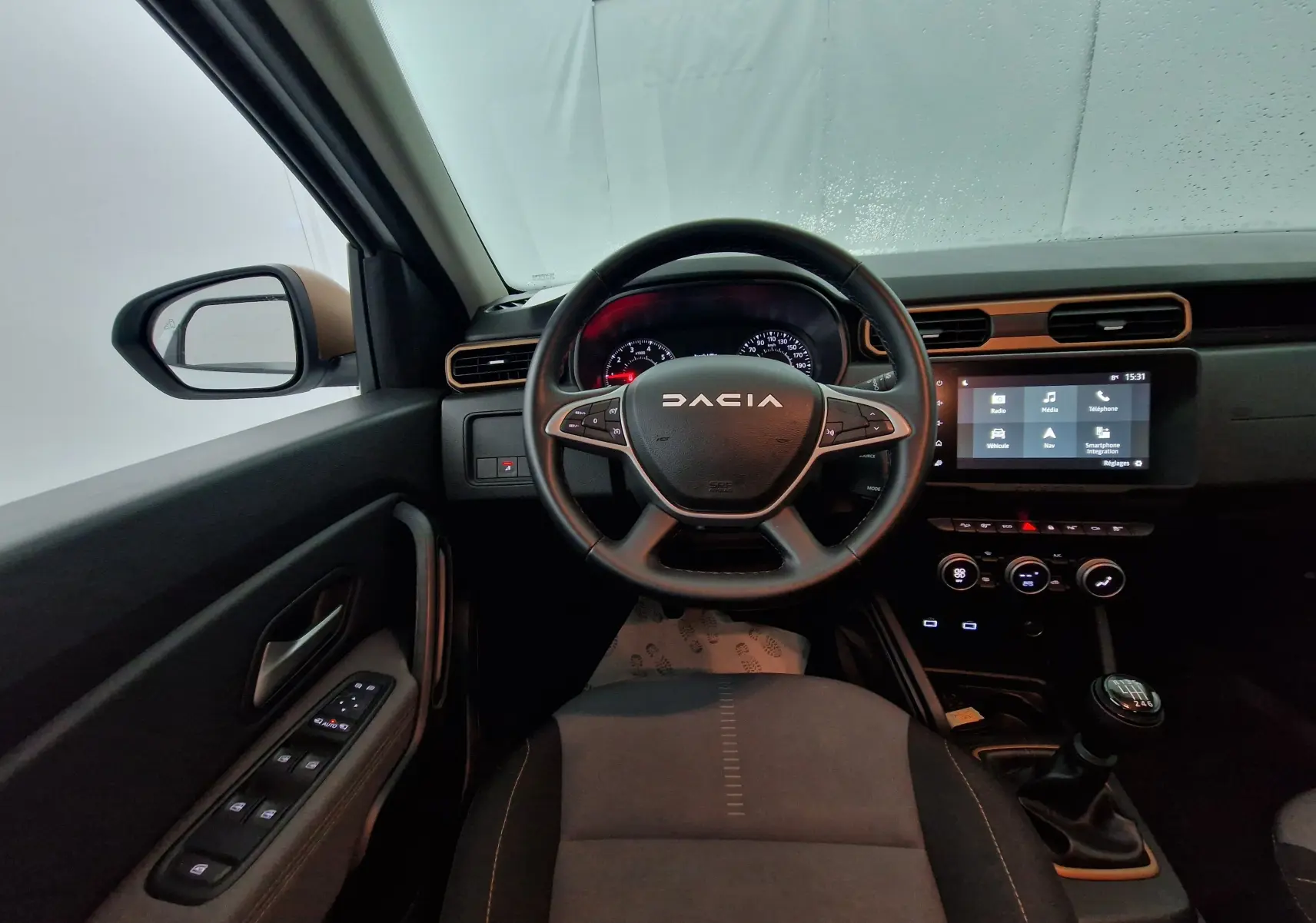 Intérieur du Dacia Duster 2024 diesel, vue depuis le siège conducteur, volant multifonction et écran tactile central visibles.
