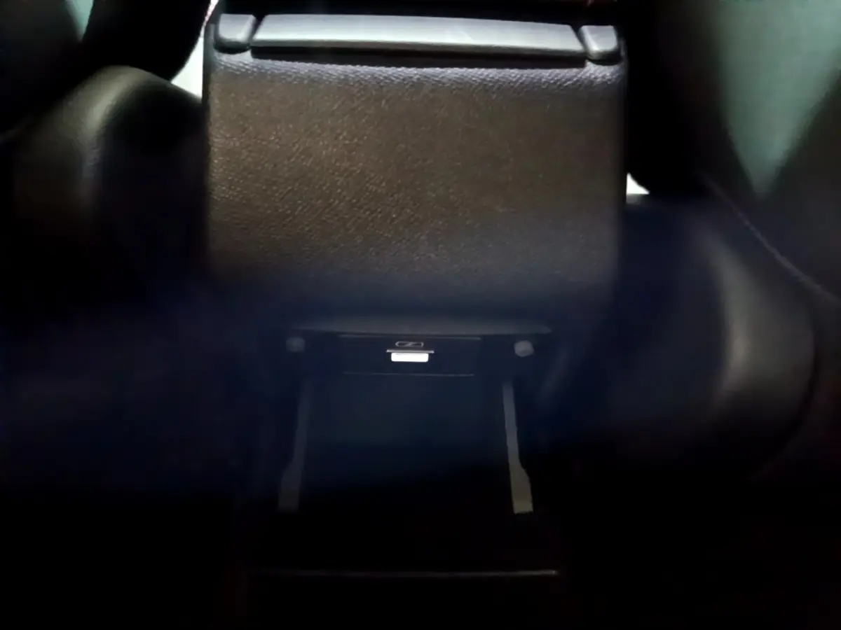 Gros plan sur la console centrale arrière noire du Peugeot 308 GT Line 2019, avec compartiment ouvert.