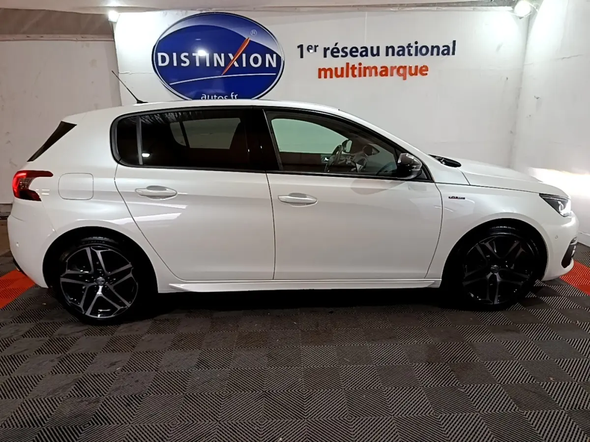 Profil droit d'une Peugeot 308 blanche Puretech 130 GT Line avec jantes noires et logo GT Line sur aile avant.