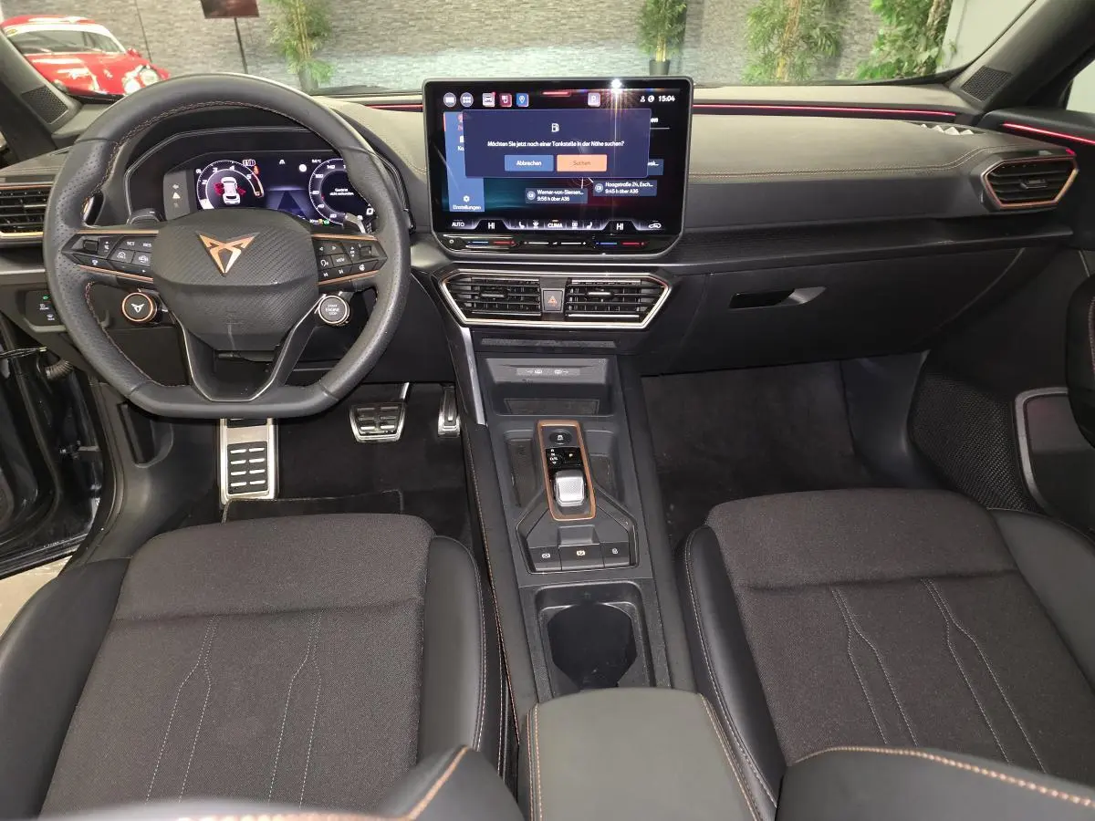 Vue intérieure avant du CUPRA Formentor 2025 avec tableau de bord noir, volant sport et écran tactile central.