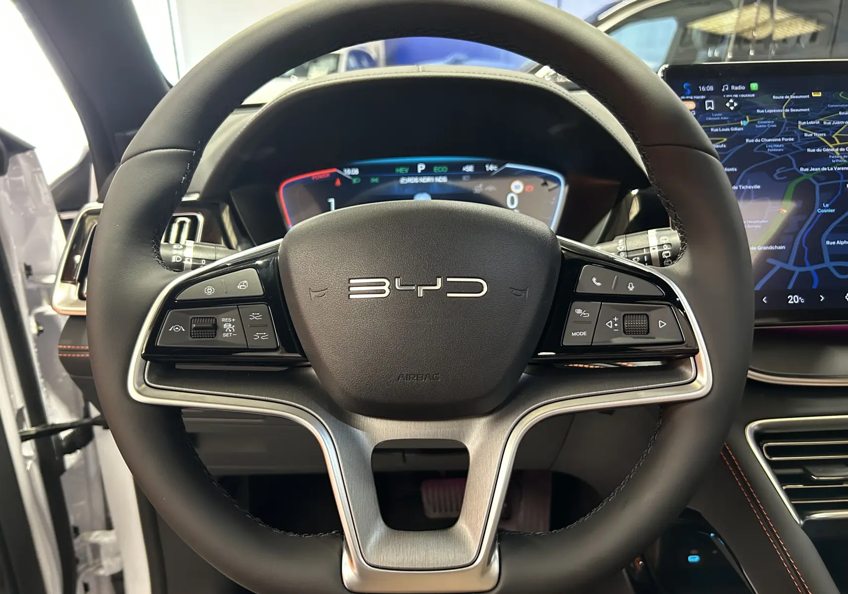 Vue rapprochée du volant noir du BYD SEAL U 2025 avec tableau de bord numérique et écran tactile latéral.