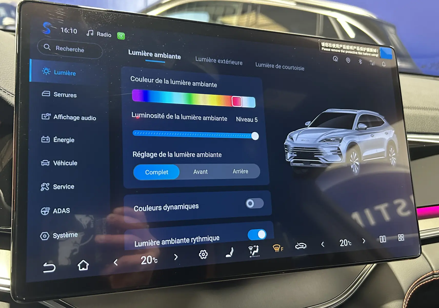 Écran tactile intérieur montrant une vue 3/4 avant droite du BYD SEAL U blanc avec réglage de lumière ambiante.