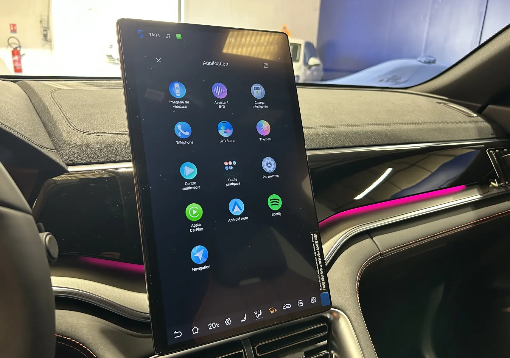 Vue intérieure du tableau de bord du BYD SEAL U avec écran tactile vertical et éclairage d'ambiance violet.