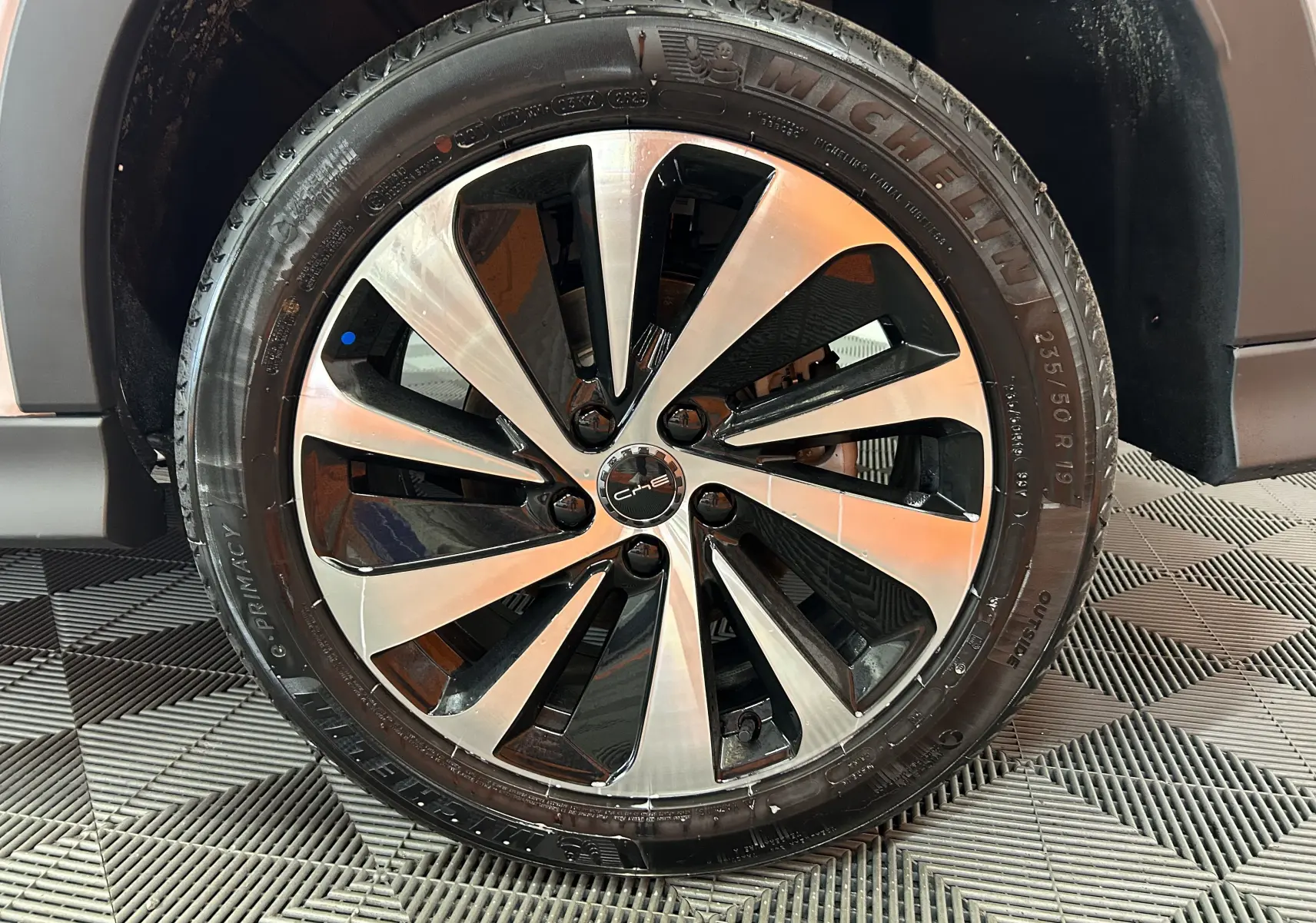 Gros plan sur la jante alliage bicolore noir et argent du BYD SEAL U Snow White Metal, avec pneu Michelin visible.