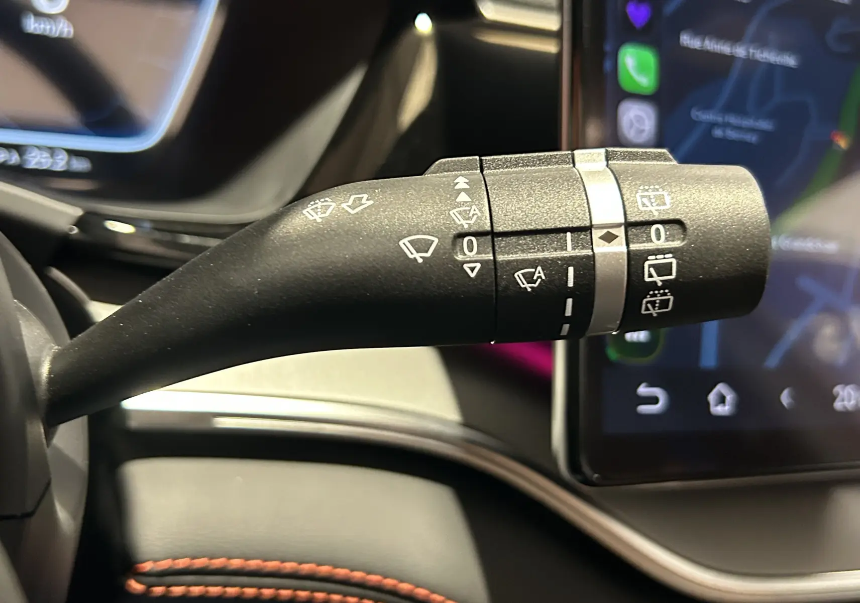 Gros plan sur la commande des essuie-glaces dans l'habitacle du BYD SEAL U, avec écran tactile en arrière-plan.