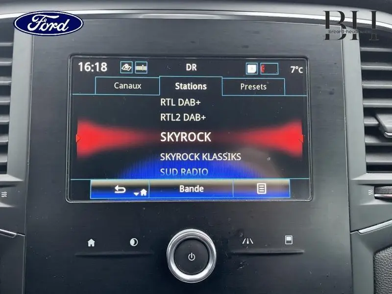 Écran tactile central de la Renault Mégane Break gris platine 2020 affichant les stations radio avec interface moderne.