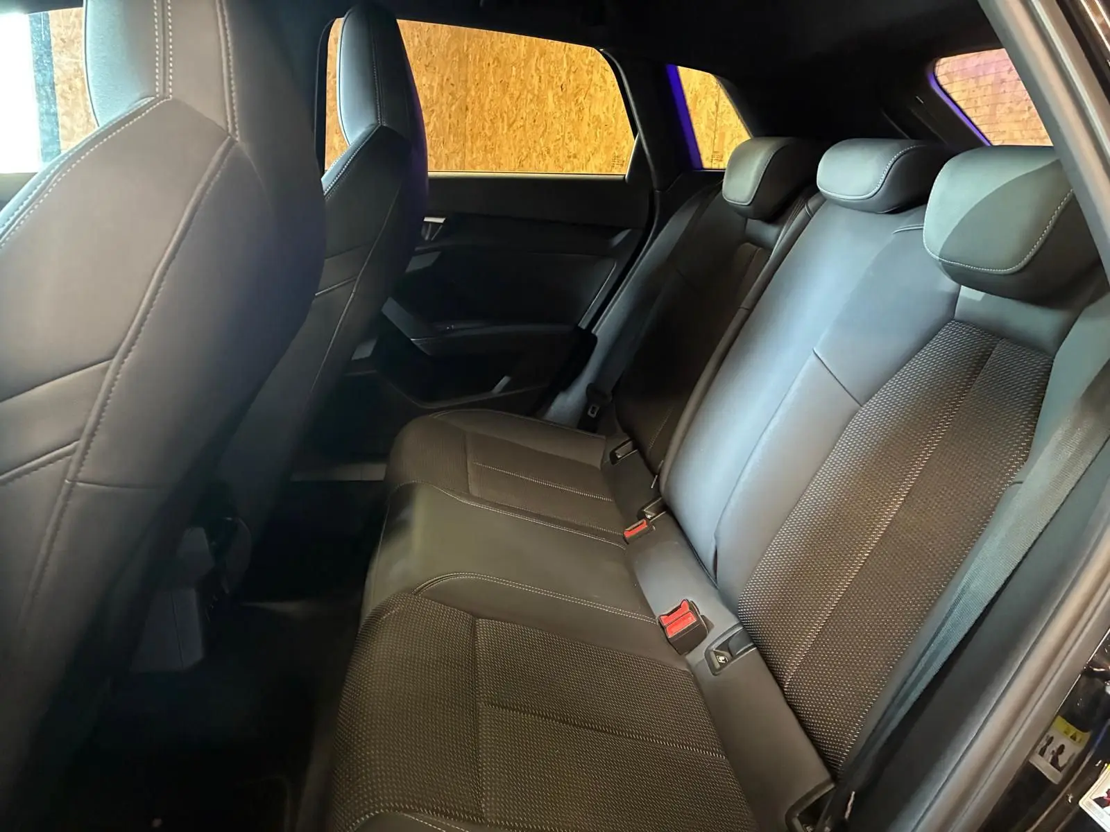Vue intérieure côté droit montrant la banquette arrière en cuir noir de l'Audi A3 Sportback 2023 S line.