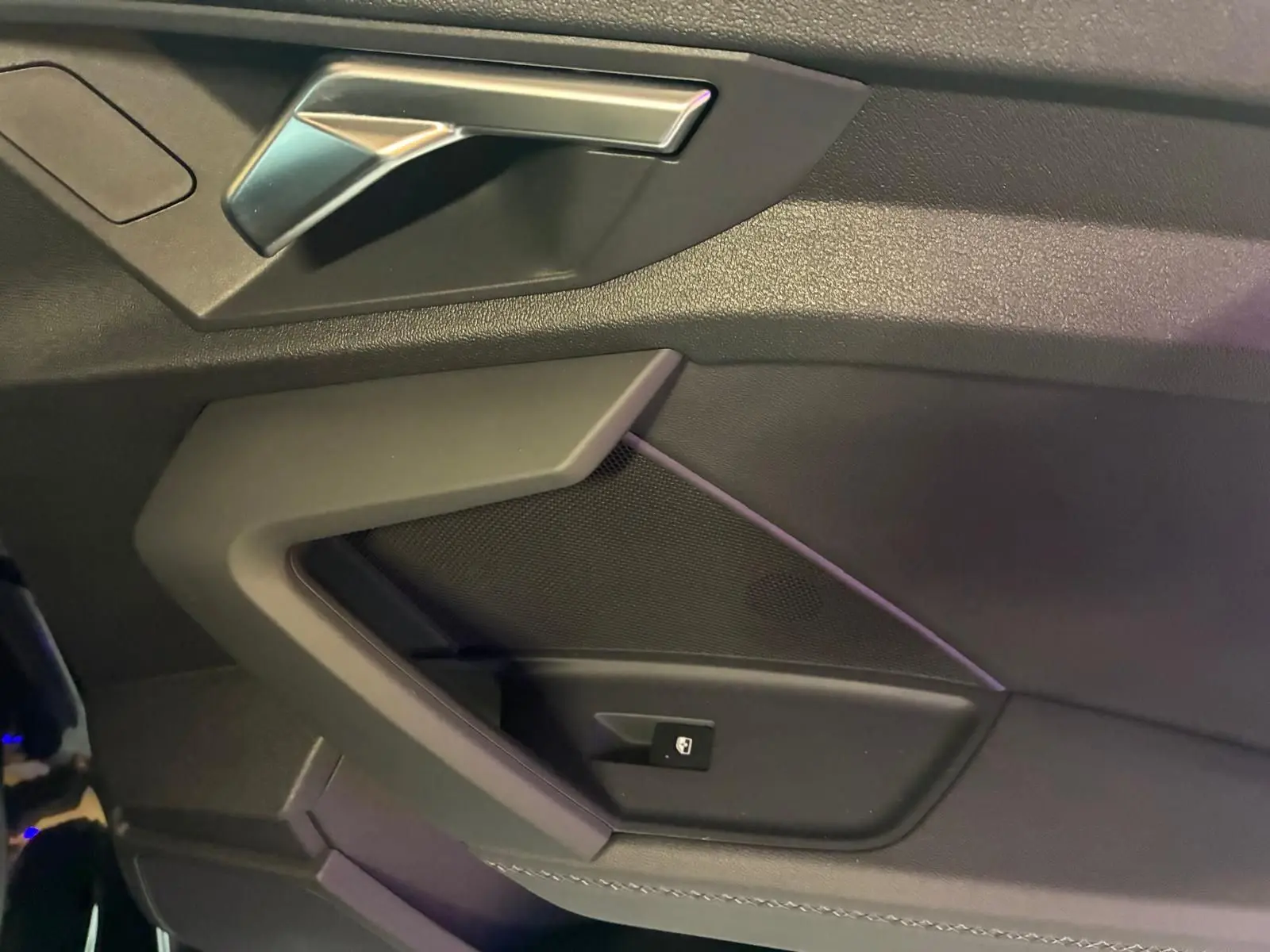 Vue rapprochée de la poignée intérieure côté gauche en similicuir noir avec insert aluminium sur Audi A3 Sportback 2023.