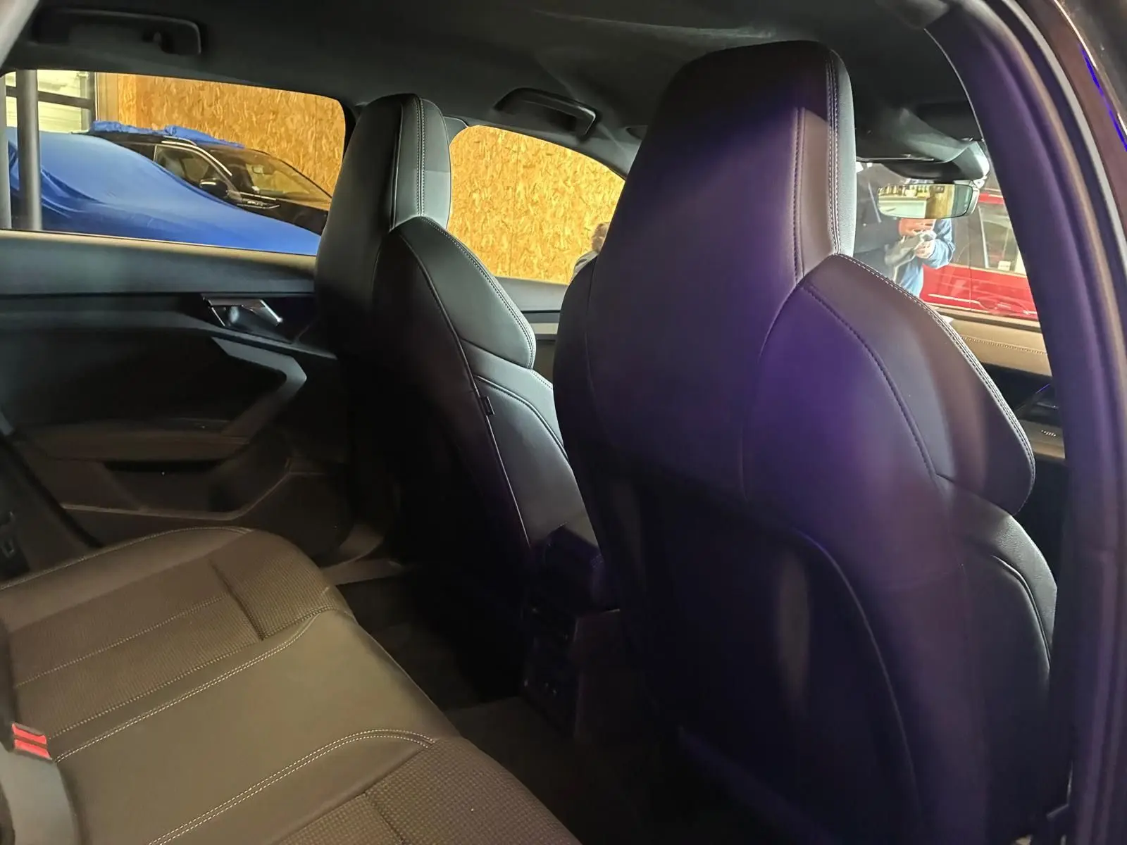 Vue intérieure arrière droite de l’Audi A3 Sportback 2023 noire, sièges sport en cuir et ciel de pavillon noir.