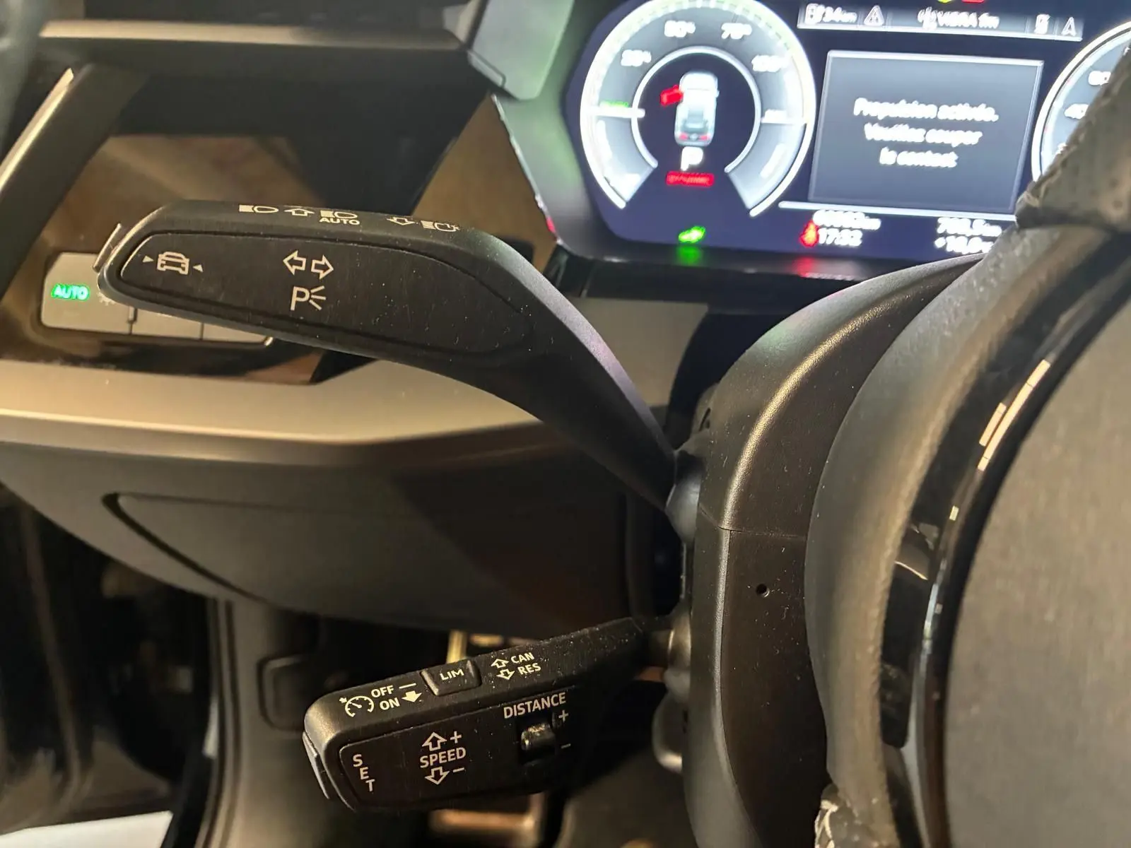 Gros plan sur les commandes au volant de l'Audi A3 Sportback 2023, affichage numérique et leviers noirs visibles.