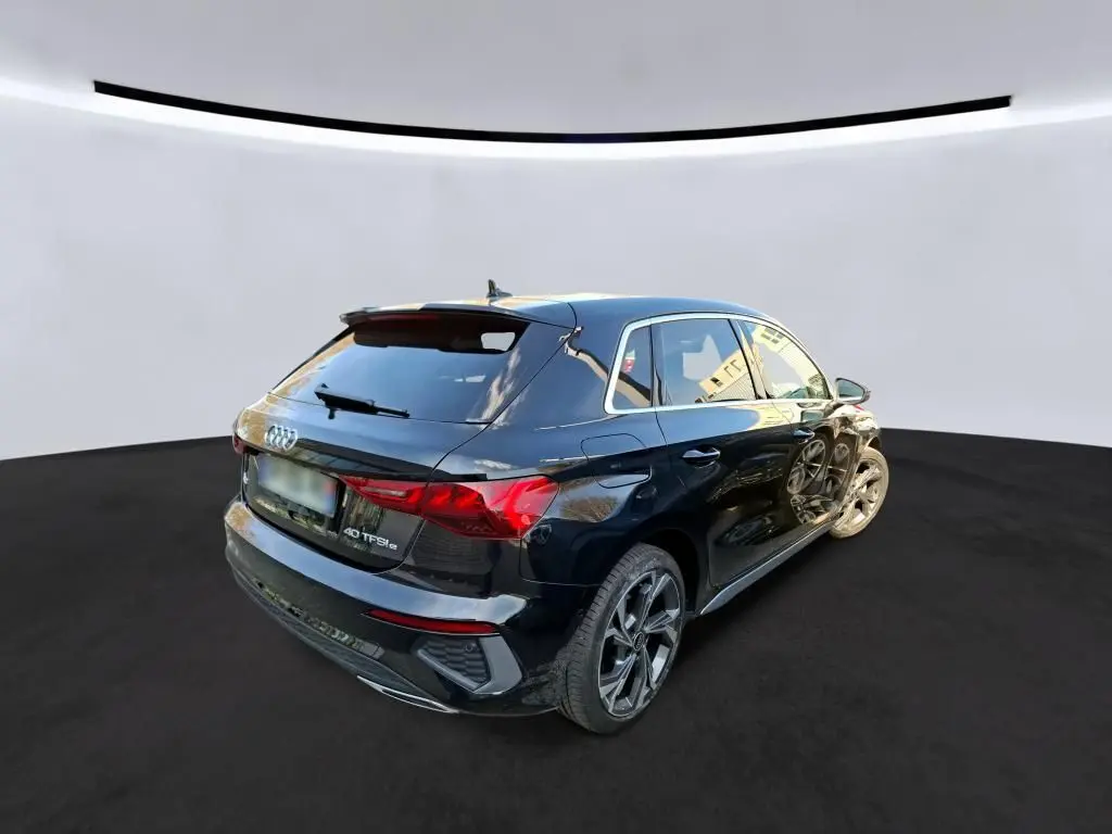 Audi A3 Sportback noir vue 3/4 arrière droit, avec jantes alliage 18'' et vitres arrière surteintées.