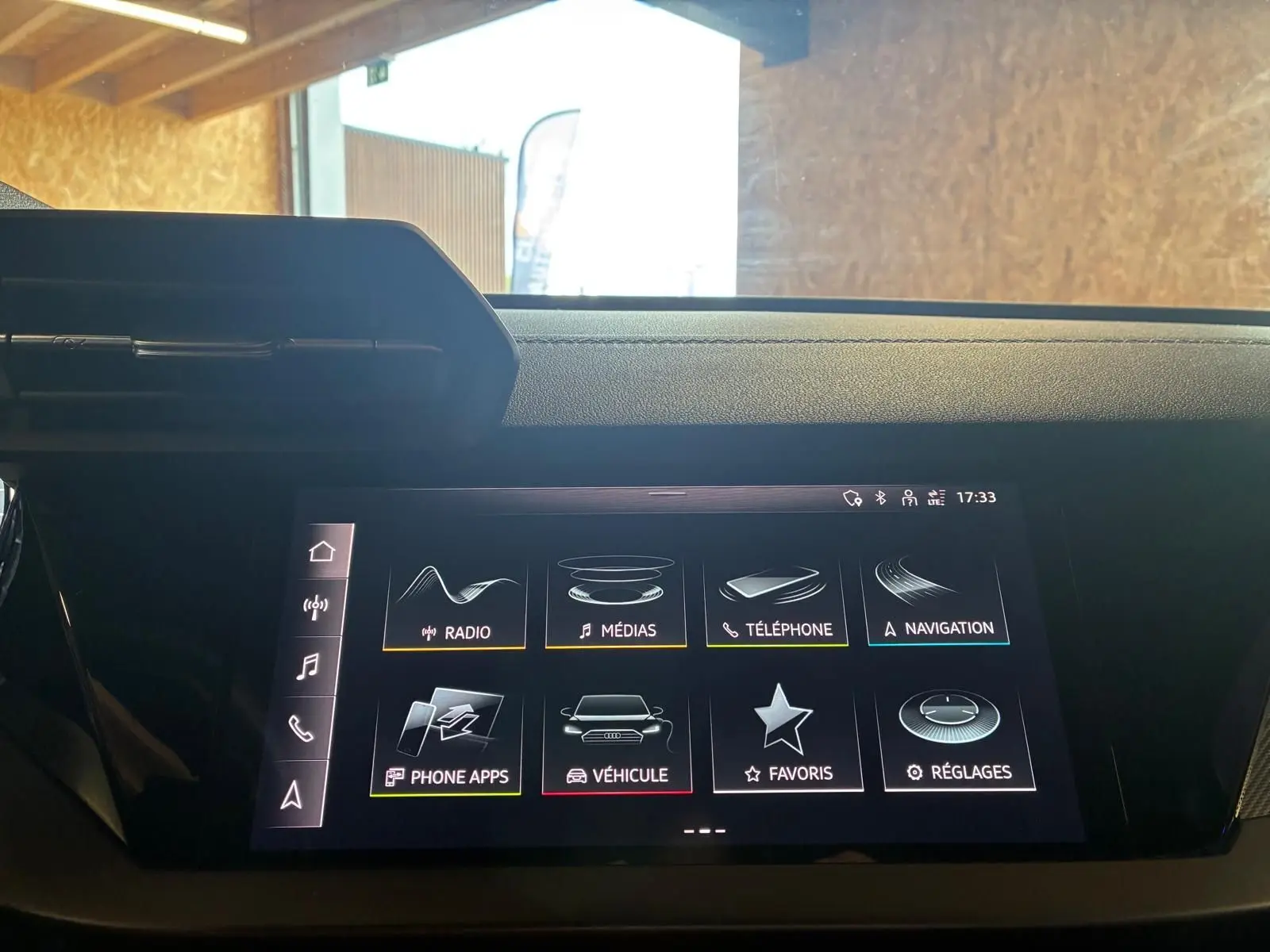 Écran tactile central de l'Audi A3 Sportback 2023 affichant le menu principal avec options multimédia et navigation.