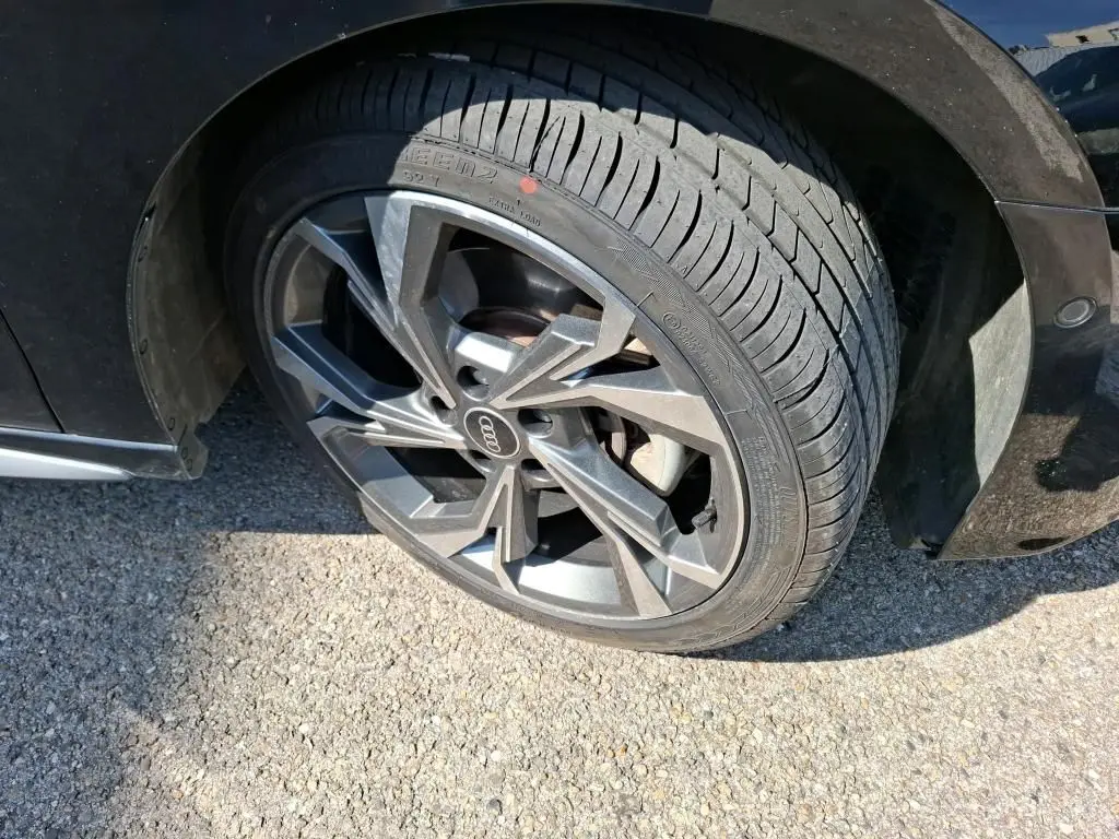 Gros plan sur la roue avant gauche noire d’une Audi A3 Sportback 2023 avec jante alliage 18'' gris graphite à 5 branches en Y.