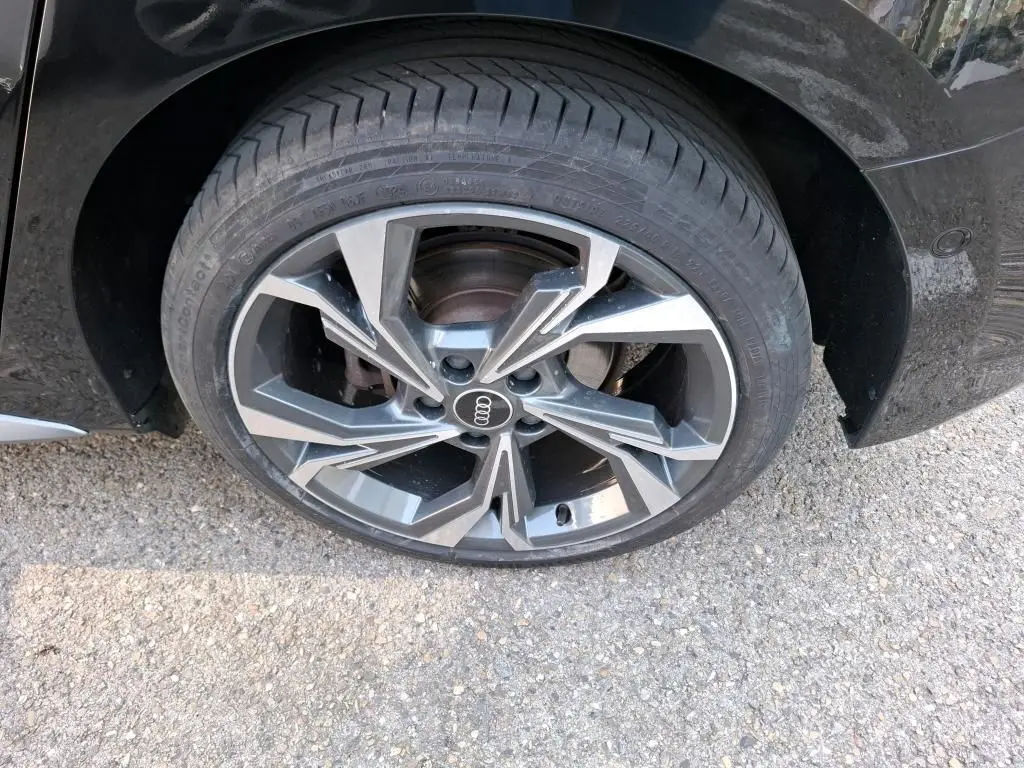 Gros plan sur la jante en alliage 18'' gris graphite à 5 branches en Y de l'Audi A3 Sportback noire côté arrière droit.