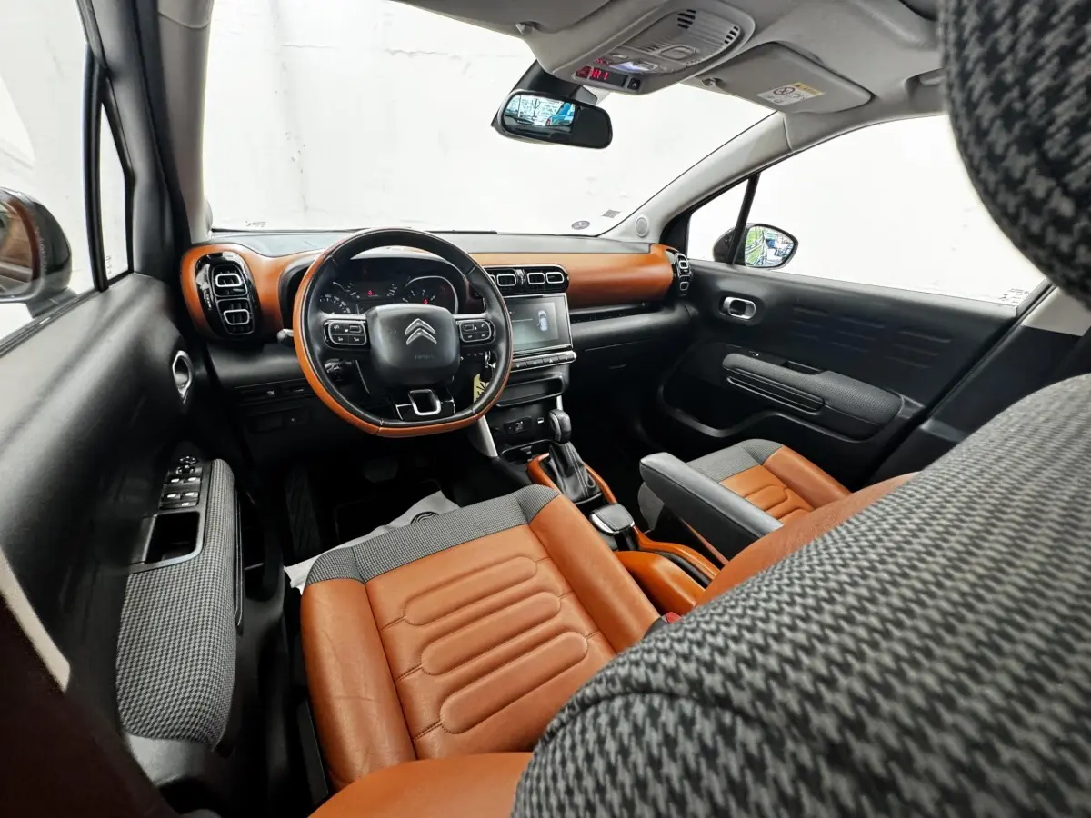 Intérieur vue avant droite du Citroën C3 Aircross 2020, sièges et tableau de bord marron et noir avec écran tactile.