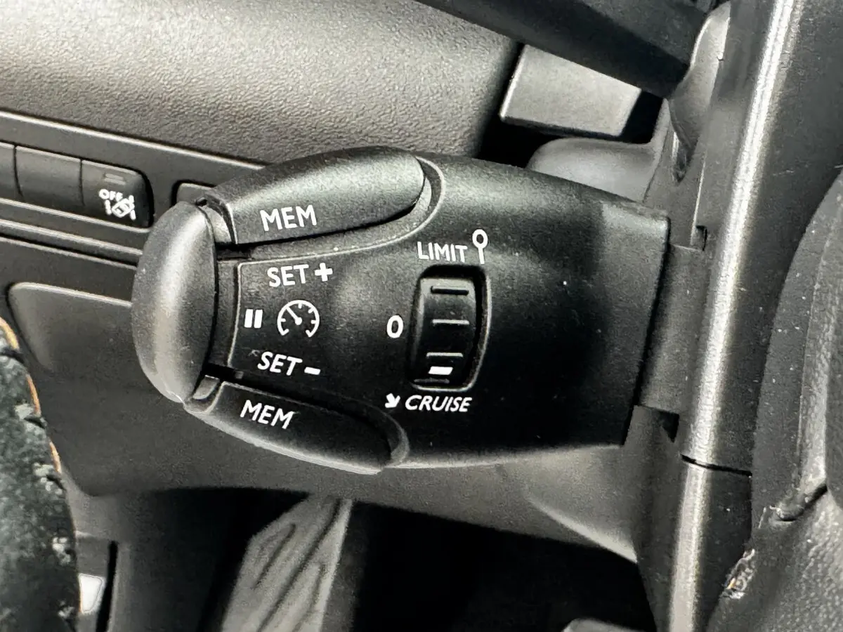 Gros plan sur la commande de régulateur de vitesse noire à gauche du volant du Citroën C3 Aircross 2020.