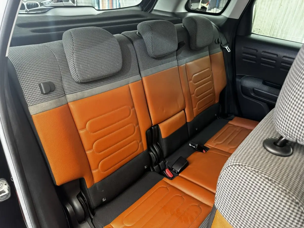 Vue intérieure sur la banquette arrière bicolore cuir marron et tissu gris à motifs du Citroën C3 Aircross 2020 noir.