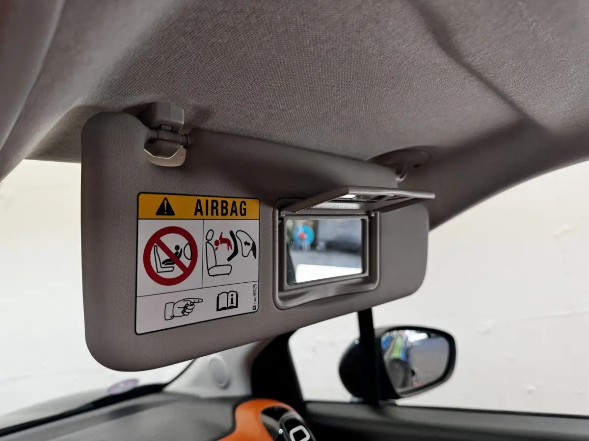 Vue intérieure du pare-soleil conducteur beige avec miroir et avertissement airbag dans une Citroën C3 Aircross noire.