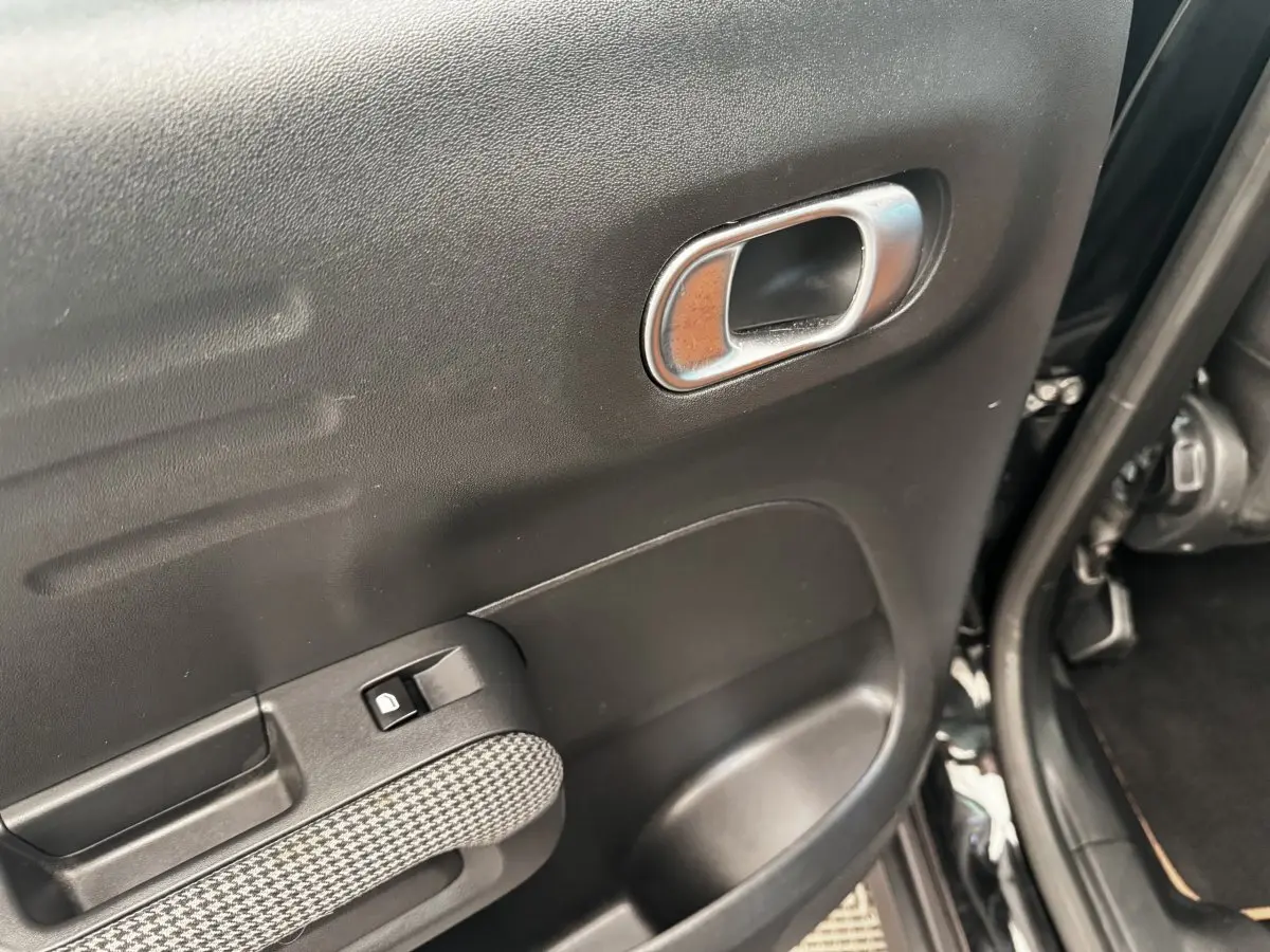 Gros plan sur la porte arrière gauche noire de la Citroën C3 Aircross 2020, avec poignée intérieure chromée et bouton de verrouillage.